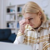 Senior woman looking stressed and upset while sitting at her computer at home after falling victim to an online scam.